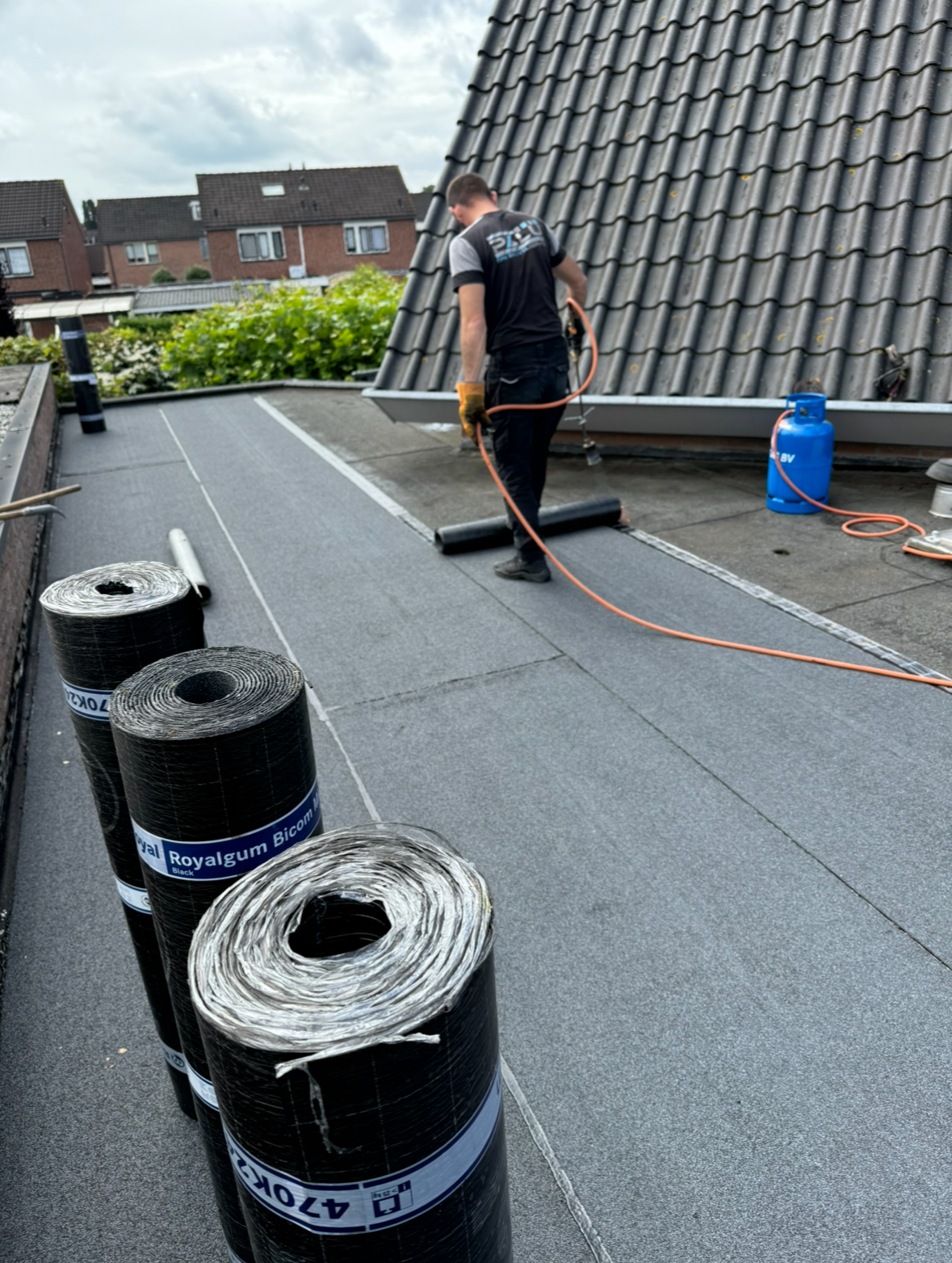 Nieuwe bitumen dakbedekking in Enschede Dakdekker brengt nieuwe bitumen dakbedekking aan op een plat dak in Enschede.