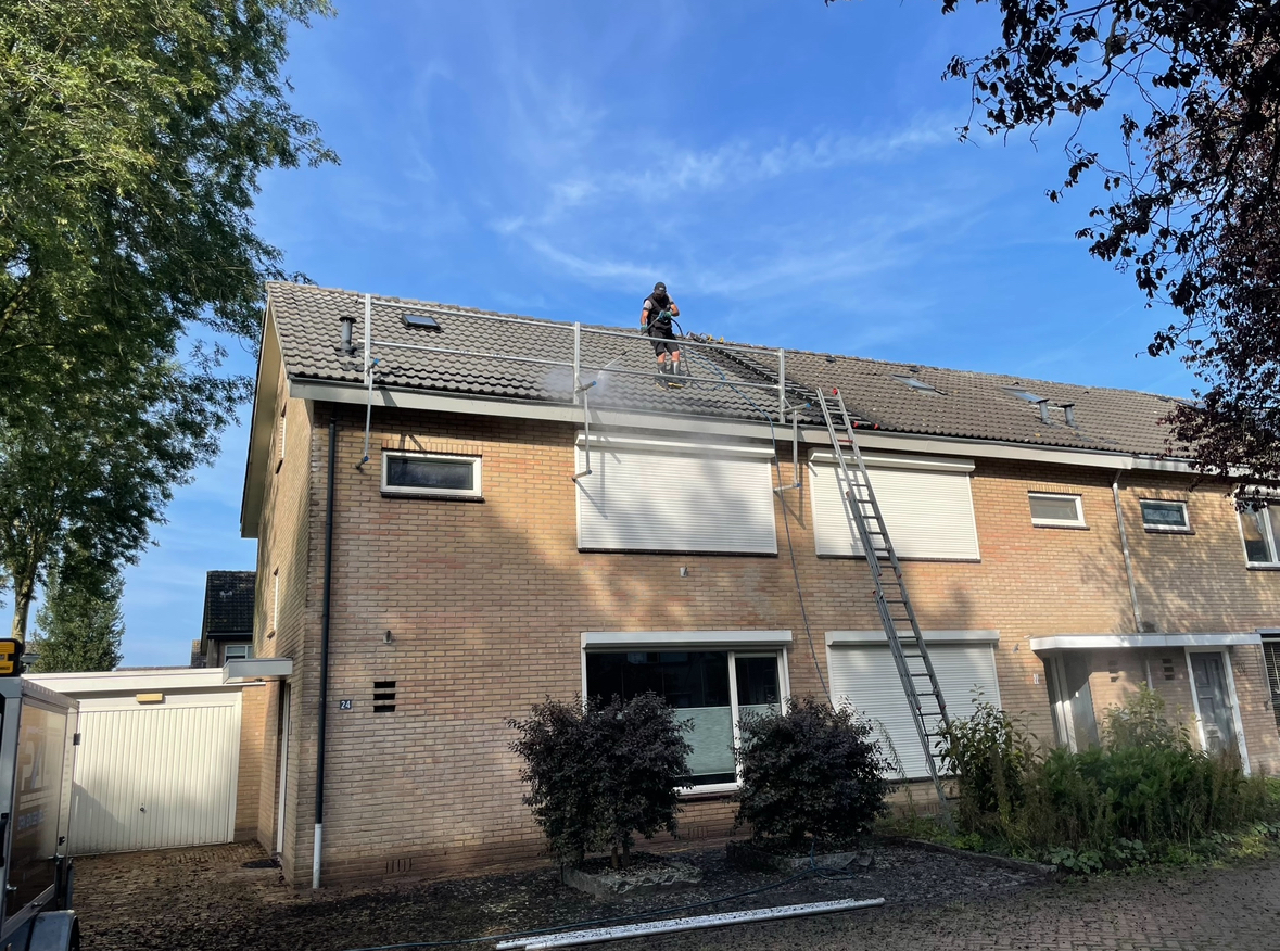 Pannendak reinigen in Enschede Dakdekker reinigt een pannendak van een woning in Enschede met professionele apparatuur.