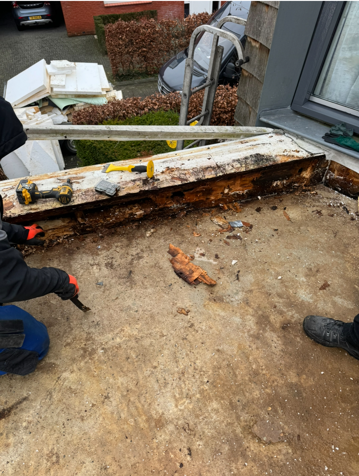 Houtrot aan dakrand herstellen in Enschede Dakdekkers verwijderen aangetast hout bij een dakrand tijdens herstelwerkzaamheden in Enschede.