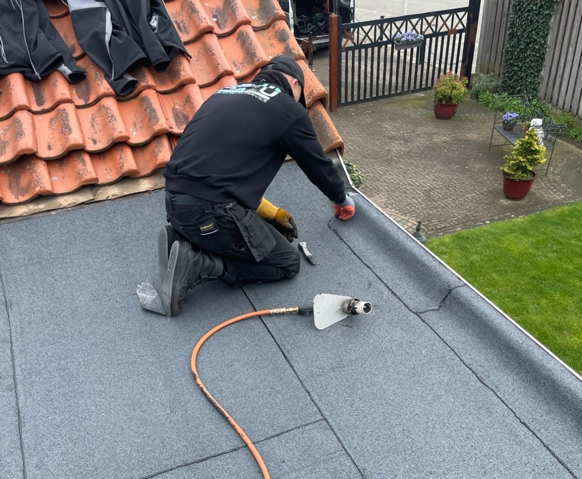 Bitumen dakreparatie op woning in Enschede Dakdekker voert een bitumen dakreparatie uit op een uitbouw in Enschede.
